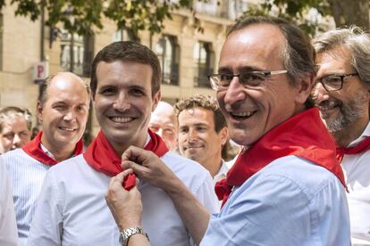 El presidente del PP del País Vasco, Alfonso Alonso pone al presidente de los populares, Pablo Casado, el pañuelo festivo durante la visita de éste a Vitoria.