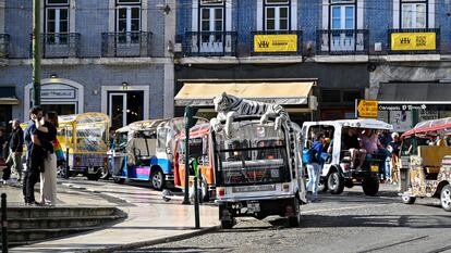 Varios tuk-tuk estacionados en la plaza de Camões aguardan la llegada de turistas. El turismo generó 25.000 millones de euros en Portugal en 2023.