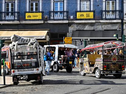 Varios tuk-tuk estacionados en la plaza de Camões aguardan la llegada de turistas. El turismo generó 25.000 millones de euros en Portugal en 2023.