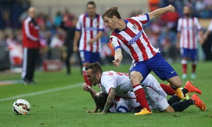 El jugador del Sevilla Aleix Vidal cae sobre God&iacute;n, en una jugada en la que interviene tambi&eacute;n Ansaldi.