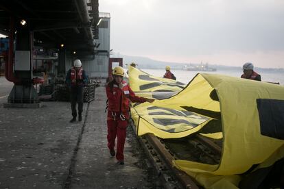 Los ecologistas comienzan a desplegar una de sus pancartas en el muelle.