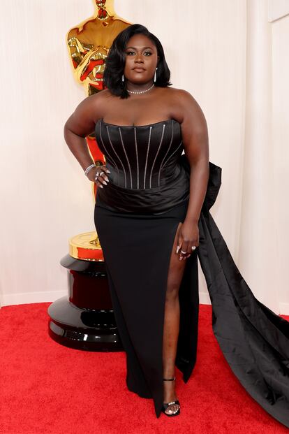 Danielle Brooks, nominada como mejor actriz secundaria por 'El color púrpura', con un vestido palabra de honor negro, con amplia cola y marcada abertura lateral.