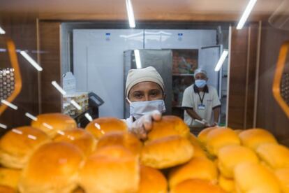 Edinesia, 26 anos. Atrás está o colega Gilberto, 44 anos. Eles trabalham numa padaria. "Não temos contato direto com os clientes. Eles pegam os pães, os doces e as outras coisas nas prateleiras. Mas sempre temos muito cuidado, usamos máscara e luvas. Às vezes, é uma agonia com este calor mas sabemos muito bem o quanto é importante."