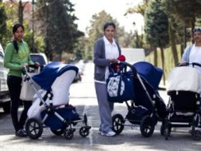 De izquierda a derecha Isabel, Paola y Glenda, tres empleadas domésticas pasean bebés en la lujosa urbanización de La Moraleja, en Madrid