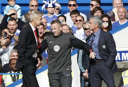 El cuarto árbitro, Jonathan Moss, separa a los entrenadores del Arsenal, Arsene Wenger, y del Chelsea, José Mourinho, durante un partido de la Premiere en Stamford Brigde, el 5 de octubre de 2014.