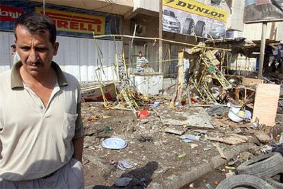 Un iraquí contempla los daños causados por la explosión de una bomba en un mercado de Bagdad, que mató a ocho personas.