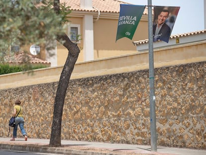 Una vecina de Dos Hermanas (Sevilla) pasea junto a un cartel electoral del PP.