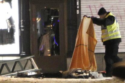 Un agente cubre un cadáver tras la explosión registrada en una céntrica calle de Estocolmo.