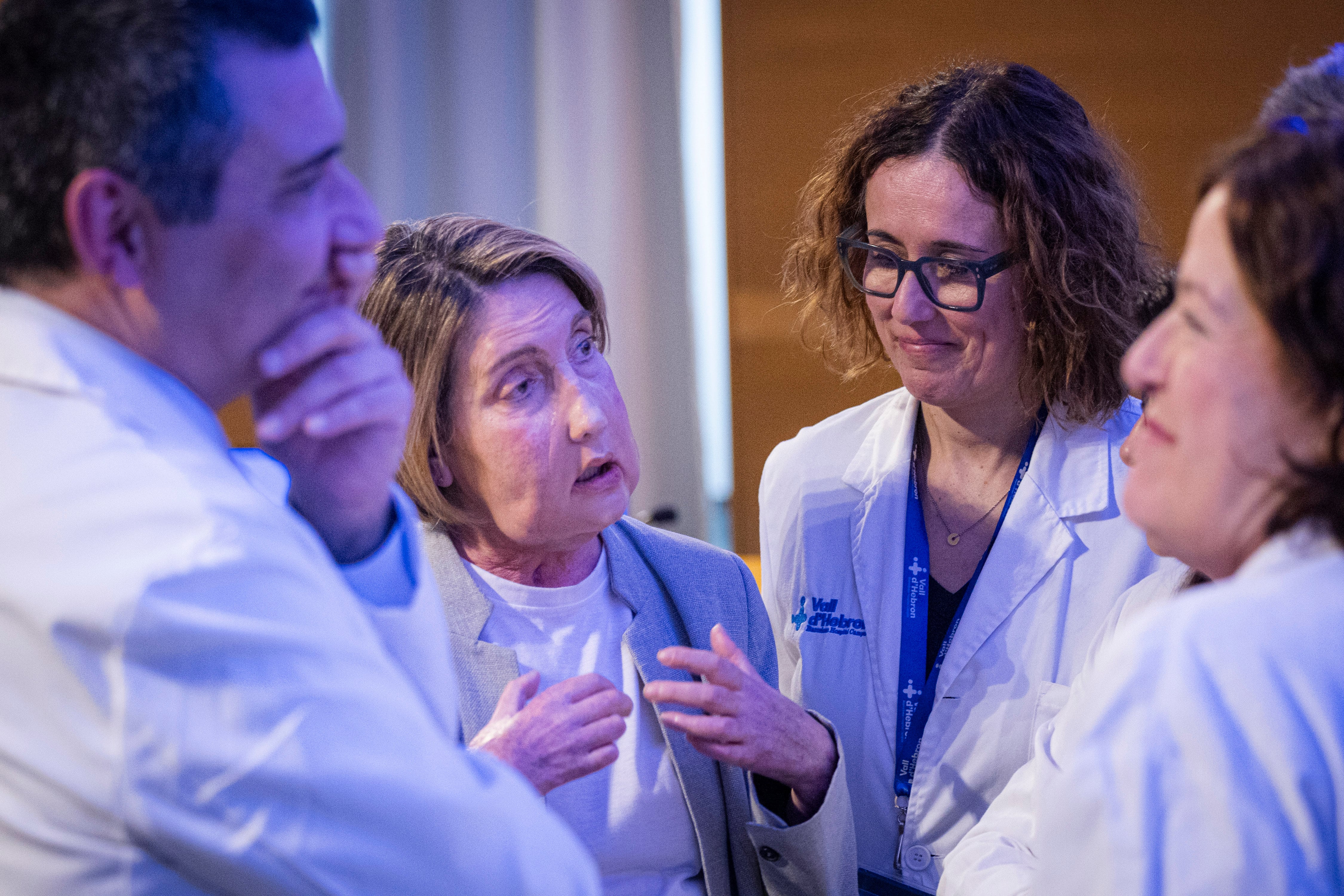 Carme (en el centro), que recibió un trasplante de cara, charla con el equipo médico del Hospital Vall d'Hebron donde se realizó la intervención.