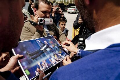 Guardiola firma una foto a un aficionado tras el entrenamiento de ayer.