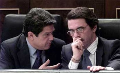 El ministro de Defensa, Federico Trillo, conversa con Aznar durante la sesión parlamentaria de ayer.