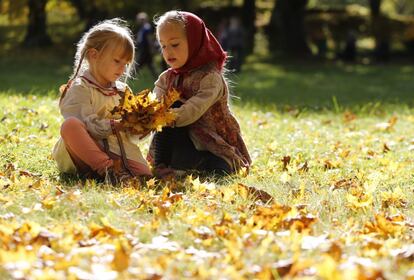 Dos niñas juegan con hojas secas en Viazynka, a 40 kilómetros de Minsk (Bielorrusia), el 1 de octubre de 2016.