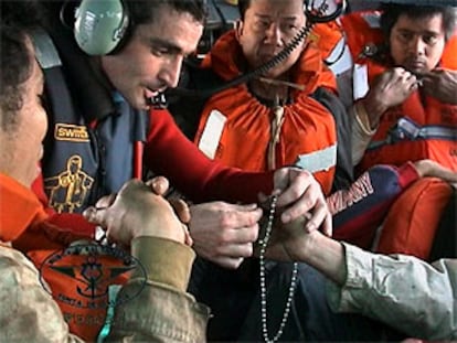 Tripulantes filipinos y griegos, dentro del helicóptero que les rescató del petrolero siniestrado.