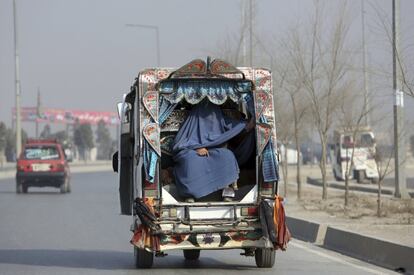 Una mujer afgana sentada en la parte trasera de una camioneta de pasajeros de tres ruedas en Kabul (Afganistán).

