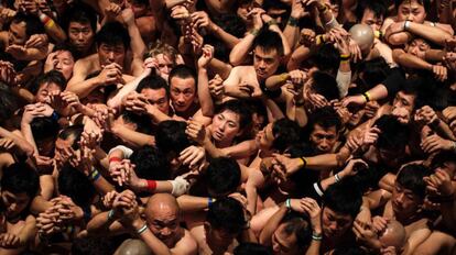 Una multitud de fieles espera a que el sacerdote les lance bastones sagrados en el templo Saidaiji de Okayama (Japón).