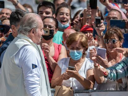 El rey emérito Juan Carlos I se dirige a saludar a los ciudadanos que le esperan en el club náutico de Sanxenxo este viernes.