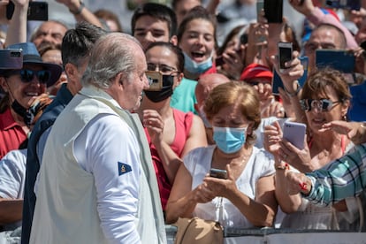 El rey emérito Juan Carlos I se dirige a saludar a los ciudadanos que le esperan en el club náutico de Sanxenxo este viernes.