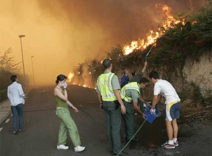 Guardias civiles ayudan a extinguir un incendio el pasado agosto en la urbanización de Aldeanova, cerca de Santiago.