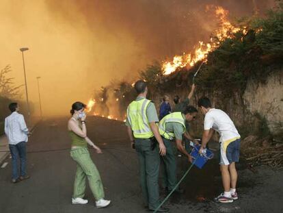 Guardias civiles ayudan a extinguir un incendio el pasado agosto en la urbanización de Aldeanova, cerca de Santiago.