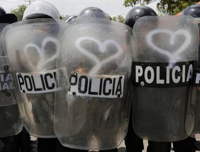 Un grafiti con forma de corazón es dibujado en los escudos policiales durante la manifestación contra el presidente de Nicaragua, Daniel Ortega, en Managua, el 23 de septiembre de 2018.