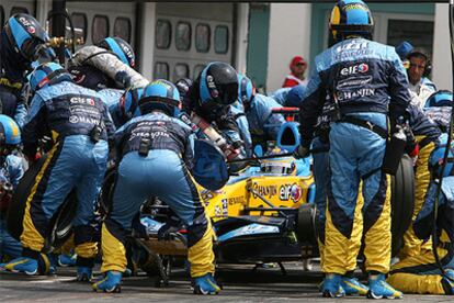 Los mecánicos de Renault, durante la operación de cambio de neumáticos del coche de Fernando Alonso.