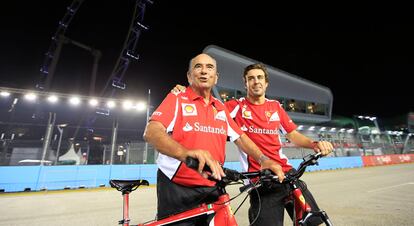 Fernando Alonso y Emilio Botin posan después de dar una vuelta en bicicleta por el circuito de Singapur