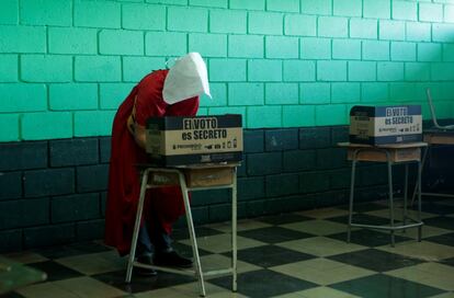 Una activista, caracterizada como en la serie de televisión 'The Handmaid's Tale (El cuento de la criada)', vota en las elecciones presidenciales en un colegio electoral en San José de Costa Rica, el 1 de abril de 2018.