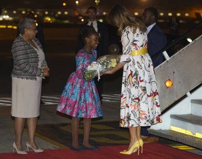 Margaret Kenyatta y una niña con flores reciben a Melania Trump a su llegada al aeropuerto de Nairobi, Kenia, el 4 de octubre.