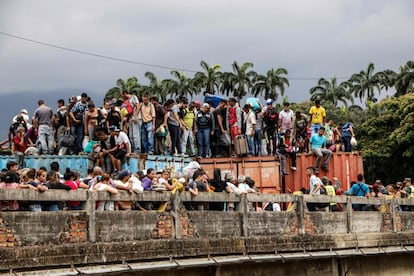 Una multitud de venezolanos permanecen en la parte superior de los contenedores que bloquean el Puente Internacional Simón Bolivar, en Cucuta (Colombia), mientras tratan de cruzar la frontera. 