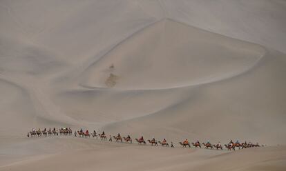 Personas montadas a camello en el desierto de Dunhuang, en China, durante la décima etapa del Silkway Rally.