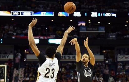 Stephen Curry lanza ante Anthony Davis.