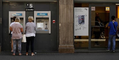 Gente saca dinero en un cajero, en La Rambla de Barcelona.