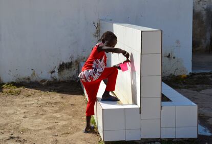 Una niña bebe de uno de los grifos construidos por el programa en la escuela infantil.