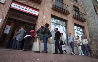 Un grupo de personas hacen cola en una oficina del Inem en Alcalá de Henares (Madrid).