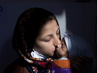 Anita, afgana de 14 años, besa a su hija de 53 días (Azita) hospitalizada en la clínica de alimentación terapéutica en Herat.