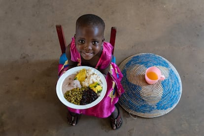 Los niños pueden sufrir las secuelas de una alimentación y unas prácticas alimentarias deficientes durante el resto de sus vidas. Una ingesta insuficiente de los nutrientes que se encuentran en las verduras, las frutas, los huevos, el pescado y la carne, todos ellos necesarios para apoyar el crecimiento a una edad temprana, agravan el peligro que corren los pequeños de padecer deficiencias en su desarrollo cerebral y su aprendizaje. Nakalema Betty, ugandesa de tres años y seis meses, sostiene un plato de una comida nutritiva con arroz, 'matooke' (puré de plátano), crema de cacahuete, vegetales de hojas rojas, aguacate y guisantes. A su lado, una taza con zumo de fruta fresca.