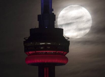 La Superluna dentras de la Torre CN de Toronto, Canadá.