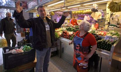 Francesc Anyó parla amb Amparo Alcolea, davant la seua parada de fruites i verdures al Mercat Central de València.