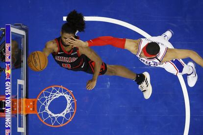 Coby White, de los Chicago Bulls (a la izquierda), recibe una falta de Tobias Harris de los Philadelphia 76ers durante la segunda mitad de un partido de baloncesto de la NBA, en Filadelfia (EE UU).