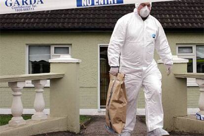 La policía se lleva pruebas de la casa a las afueras de Cork donde se encontró el supuesto dinero del golpe.