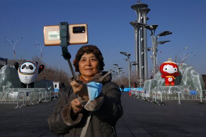 Una mujer se hace un selfi cerca de las mascotas de los Juegos Olímpicos y Paralímpicos de Invierno de Pekín 2022 (China). El Comité Organizador de Pekín para los Juegos Olímpicos de Invierno de 2022 afirmó que por el momento no contempla confinar la capital china ante el reciente aumento de casos de coronavirus registrados en el país en los últimos días.