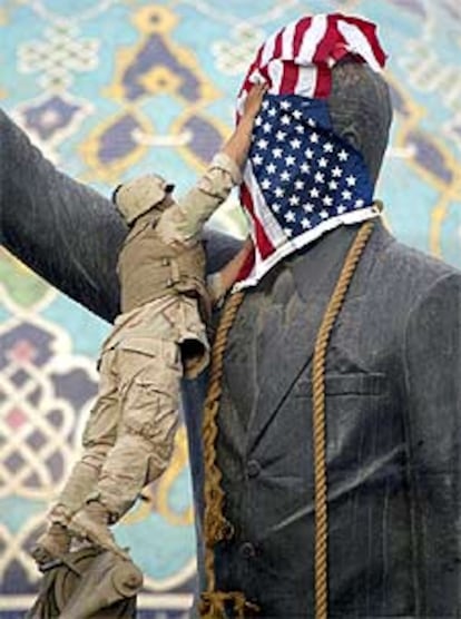 Un soldado tapa con una bandera de Estados Unidos la cara de la estatua de Sadam que presidía una plaza en el centro de Bagdad y que minutos después sería derribada.