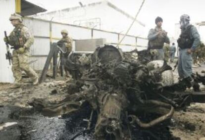 Soldados afganos y de la OTAN inspeccionan los restos de un coche bomba, ayer en Herat (oeste de Afganistán).