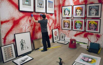 Un empleado de Sotheby's se prepara para colocar varias obras del artista urbano británico Banksy. La muestra estará abierta al público desde el próximo 11 de junio hasta el 25 de julio.