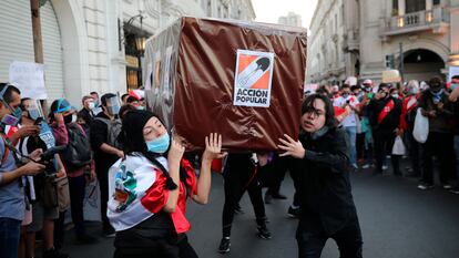 Manifestantes cargan una caja que representa un ataúd del partido político 'Acción Popular', en la Plaza San Martín en Lima (Perú), en 2020.