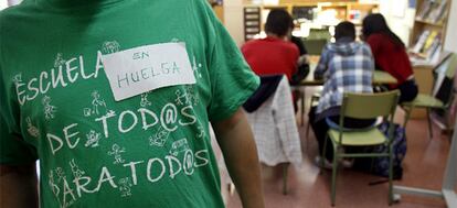 Un profesor del instituto Ignacio Ellacuría de Alcorcón (Madrid) luce una camiseta en favor de la escuela pública y un cartel anunciando la huelga en la biblioteca del centro