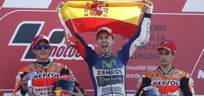 Jorge Lorenzo (Movistar Yamaha), ayer, tras ganar el mundial de Moto GP, en el podio de Cheste junto a Marc M&aacute;rquez y Dani Pedrosa (ambos de Repsol Honda).