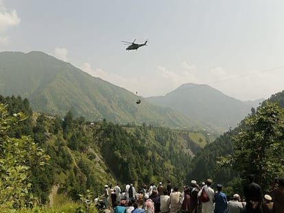 Rescate en helicóptero de uno de los menores de edad, del grupo de ocho personas, que este lunes quedó atrapado en un teleférico en Pakistán.