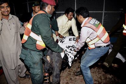 Los trabajadores de rescate paquistaníes retiran algunos cadáveres del lugar de la explosión de una bomba en un parque en Lahore, Pakistán.