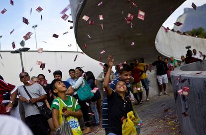 Crianças jogam santinhos de candidatos em frente a uma escola pública, próxima à favela da Rocinha, no Rio de Janeiro.